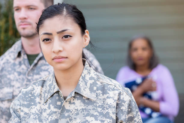 Military officers leave after giving news of soldiers' death Army soldiers leave after giving news of a fallen soldier's death to the soldier's mother. The woman is clinging to a folded flag in the background. proud army mom stock pictures, royalty-free photos & images