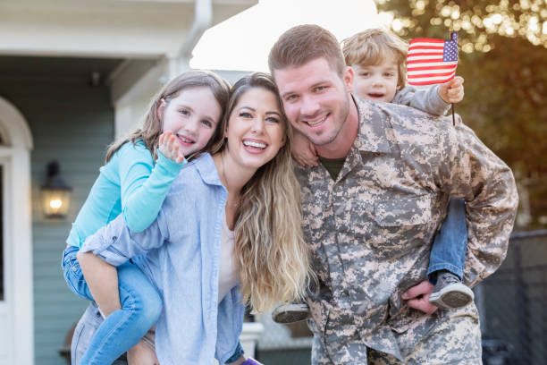 Happy soldier home from deployment Excited mid adult Caucasian soldier is happy to be reunited with his young family. four people photos stock pictures, royalty-free photos & images