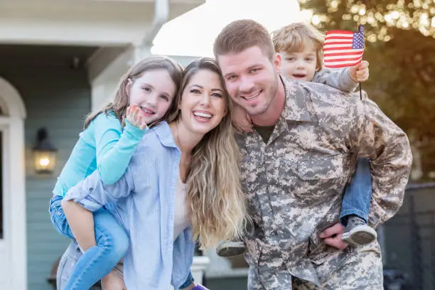 Excited mid adult Caucasian soldier is happy to be reunited with his young family.
