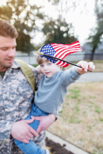 istock Army dad holds preschool age son 932608636