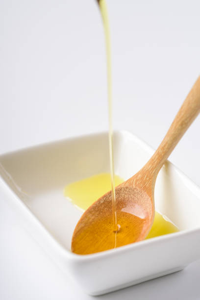 istock Pouring olive oil in a wooden spoon 932612644