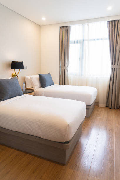 istock Well-made separate beds in small hotel room 932613232