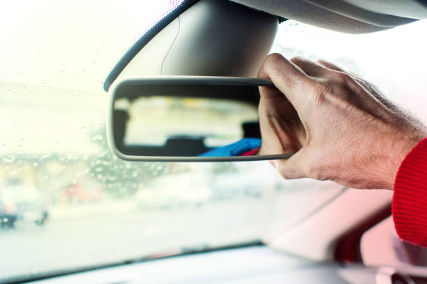 istock adjusting car's back interior mirror with right hand 932613318