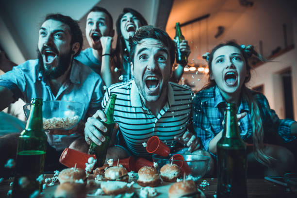 istock Excited fans having fun while cheering for their team at home. 932616738