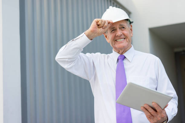 istock Happy Businessman in Helmet with Tablet at Site 932618804