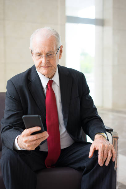 istock Serious senior executive texting message on phone 932618934