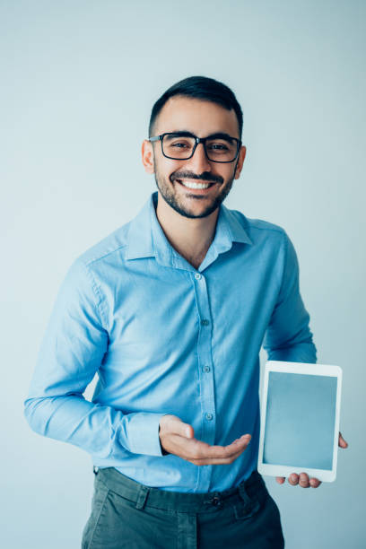 istock Happy Handsome Business Man Presenting Tablet 932624422