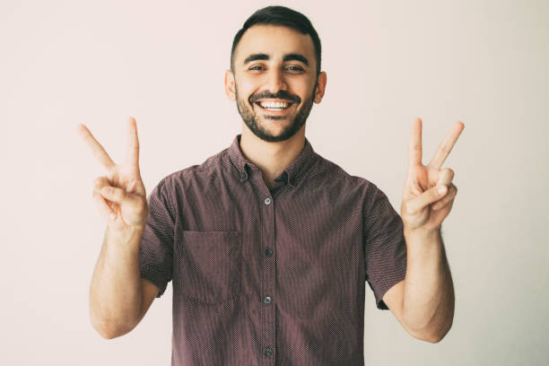 istock Happy Handsome Man Showing Victory Signs 932624466