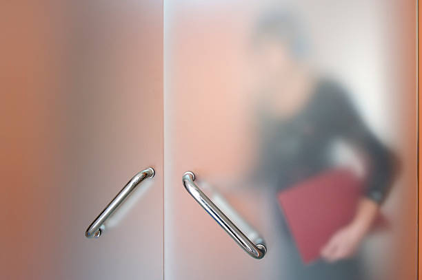 Blurry silhouette of businesswoman going to boss frosted glass door office stock pictures, royalty-free photos & images