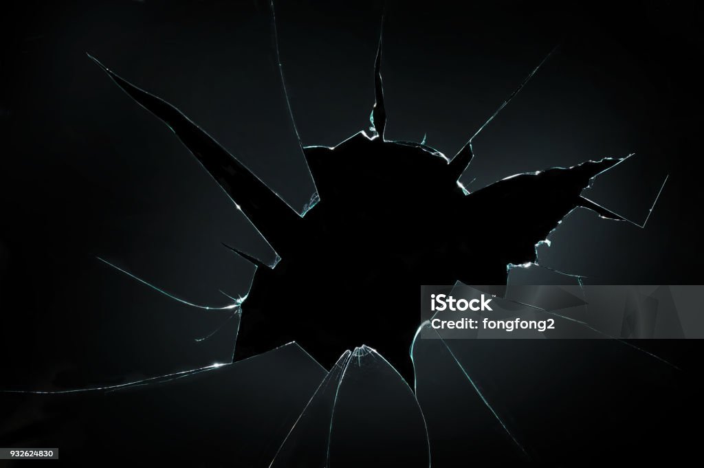 broken cracked glass with hole in black background Shattered Glass Stock Photo