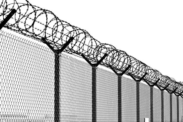 large metal fence. black and white. - razor wire imagens e fotografias de stock