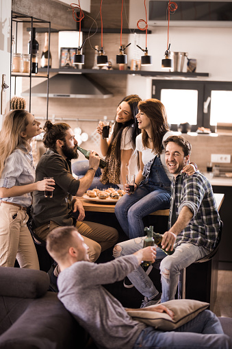 Group of young happy people having fun while communicating on a party at home.