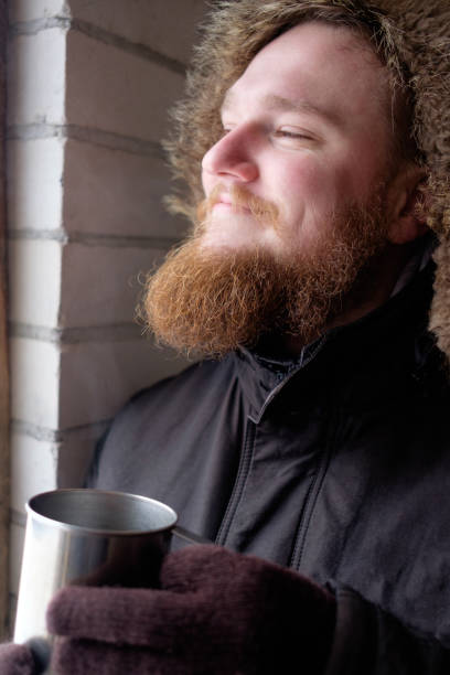 istock Redhead bearded man in polar jacket holding cup of hot coffee or tea 932627630