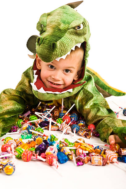 istock Young kid in a dinosaur costume lying with a load of candy 93262828