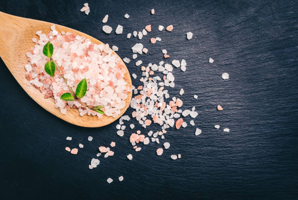 istock Himalayan salt in bamboo spoon on black slate plate 932642228
