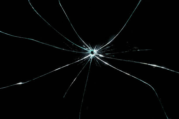 istock broken cracked glass with hole in black background 932646164