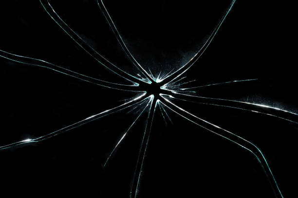 istock broken cracked glass with hole in black background 932646188