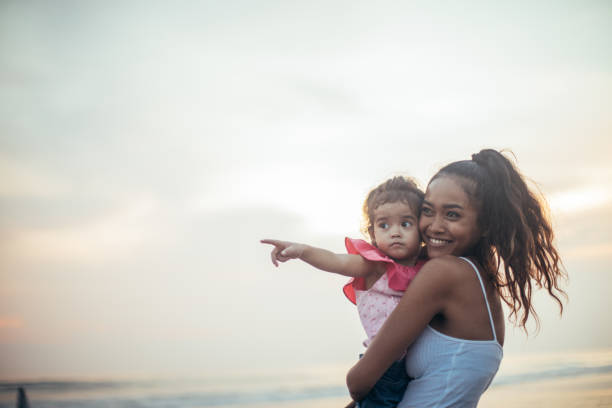istock Mother and daughter on beach 932646522