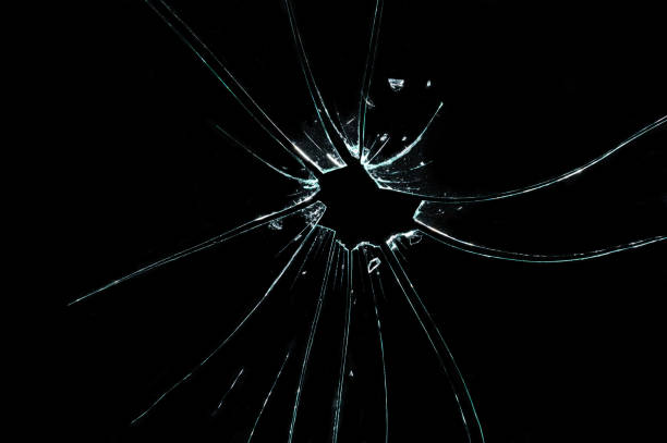 黒の背景に穴とひびの入ったガラスの破片 - bullet hole glass cracked hole ストックフォトと画像