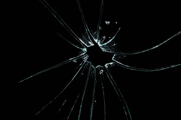 istock broken cracked glass with hole in black background 932646818
