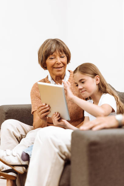 istock nephew using the tablet on the sofa with the grandparents 932650436