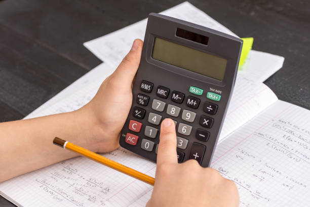 istock Finger on the Calculator Button During Mathematical Lesson. School Concept. 932651392