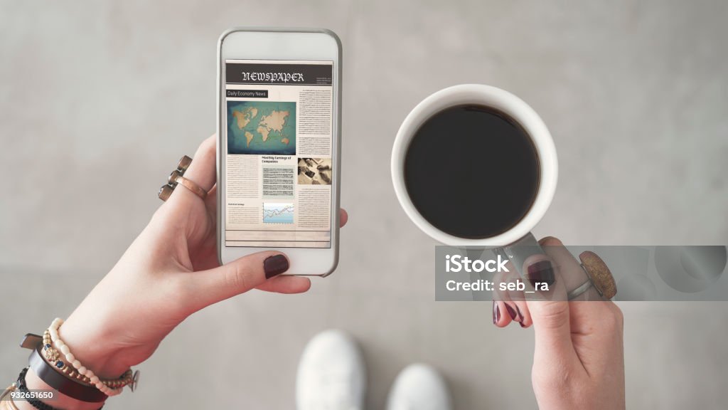 Frau halten Handys und Lesen von Nachrichten vom Bildschirm andere Hand, die Kaffeetasse - Lizenzfrei Zeitung Stock-Foto