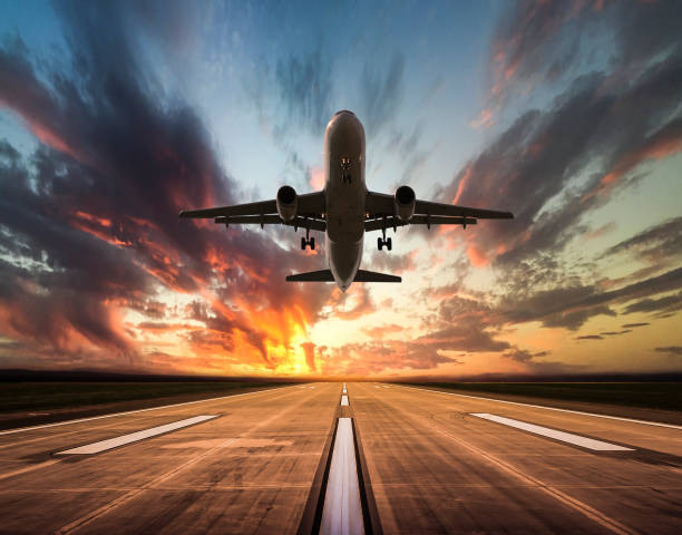 Passenger airplane taking off at sunset Passenger airplane taking off at sunset airport runway photos stock pictures, royalty-free photos & images