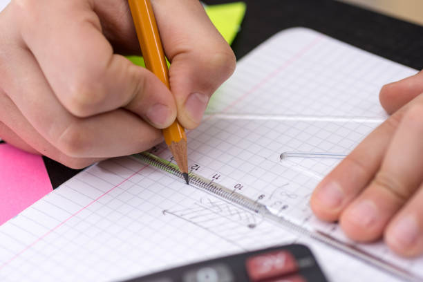 istock Mathematics Concept. Schoolboy Hands with Ruler Drawing on White Paper. 932651886