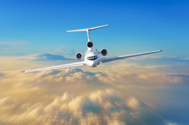 istock Passenger airplane with three engines on the tail flies high speed in the sky above the clouds and the orange sunset, the view is exactly on the cockpit of the pilots. 932654062