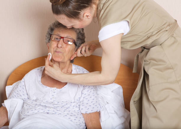 la giovane assistente sociale si prende cura di una donna anziana tra i 70 e gli 80 anni. - fare il bagno foto e immagini stock