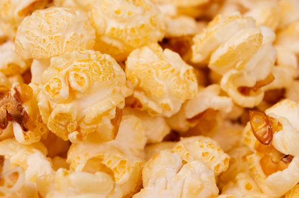 istock Ruddy golden popcorn closeup with blur background. 932657590