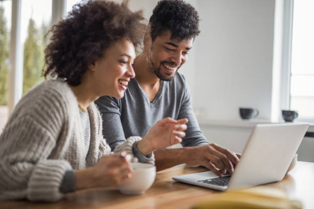 istock Happy black couple using laptop together at home. 932659068