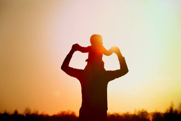 istock Father and little daughter silhouettes play at sunset 932664004