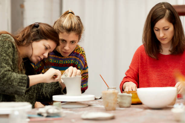 istock Woman teaching pottery to female student at table 932666790