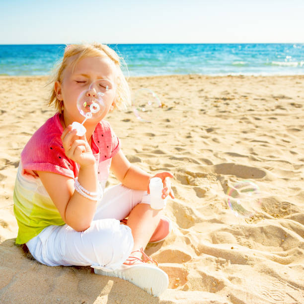 istock trendy girl on seacoast blowing bubbles 932670956