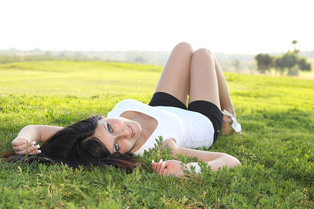 Girl lying on a grass stock photo