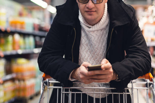 istock Man looking shopping list on smartphone 932674590