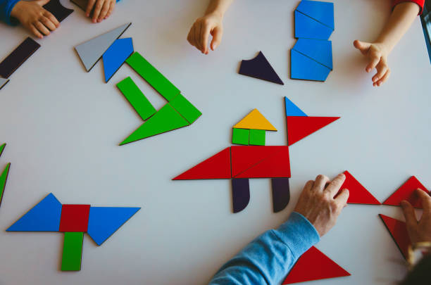 istock teacher and kids play with puzzle or tangram, education 932674726