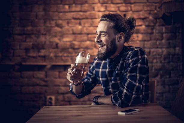 istock Happy man enjoying in beer while sitting in a bar. 932674900