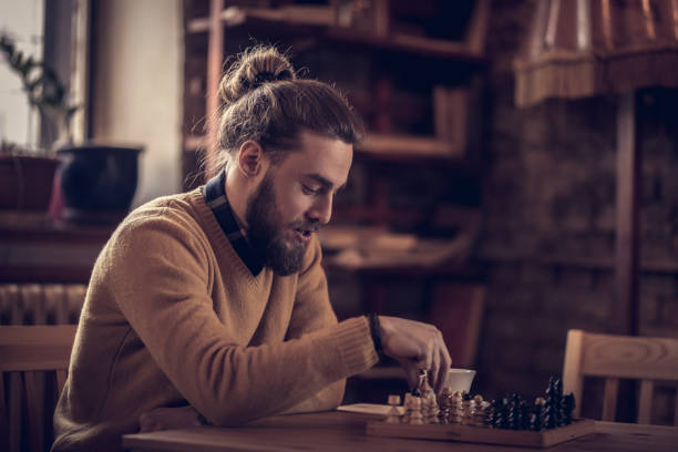 istock Young man playing chess by himself in a cafe. 932675672