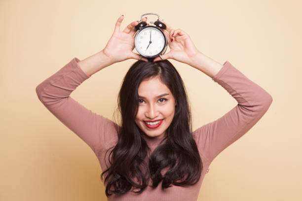 istock Young Asian woman smile with a clock. 932680418