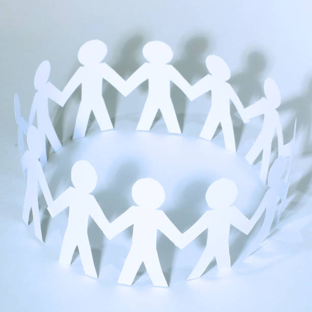 istock Team of paper doll people holding hands 932684504
