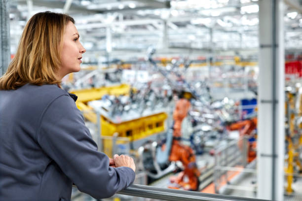 istock Female engineer looking away in car plant 932691218