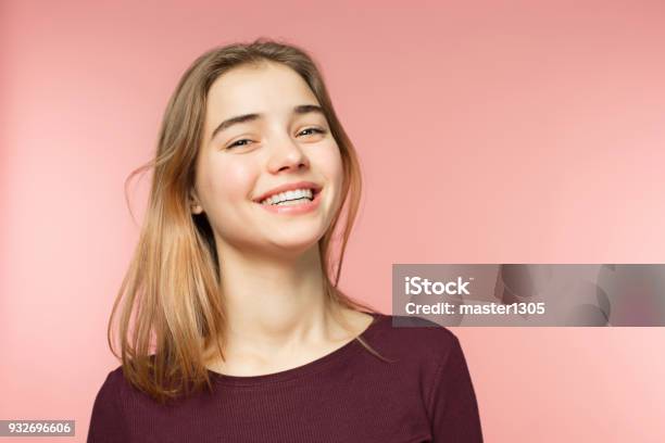 Foto de Mulher Sorrindo Com Sorriso Perfeito E Dentes Brancos Sobre O Fundo Rosa Estúdio E Olhando Para A Câmera e mais fotos de stock de Adolescente