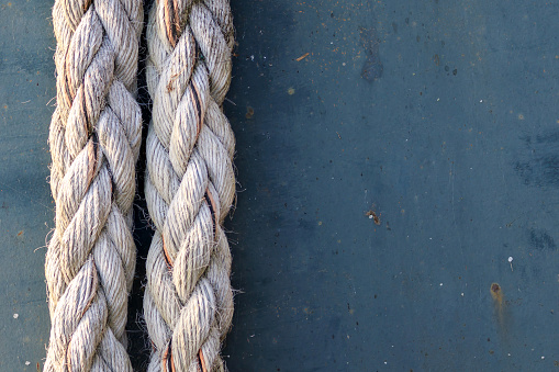 Detailed close up on weathered ship's ropes framed to the left side of the picture