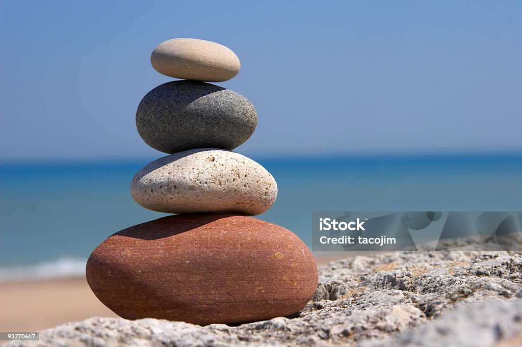 Set of four stones on top of each other signifying Zen Stacked stones at the beach Philosophy Stock Photo