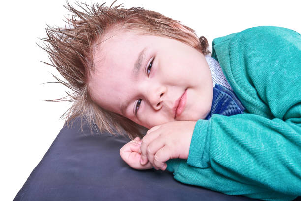 istock Little boy lying with his hands under his head, isolated on white background 932715230