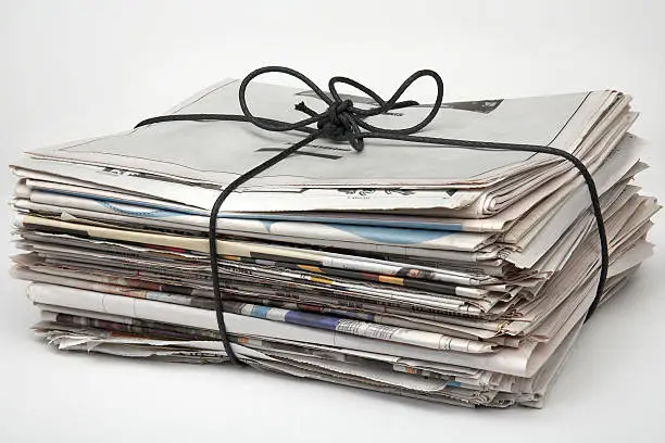 Newspapers tied up with string and ready for recycling