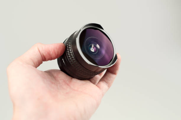 istock Old lens in hands on a white background 932723752